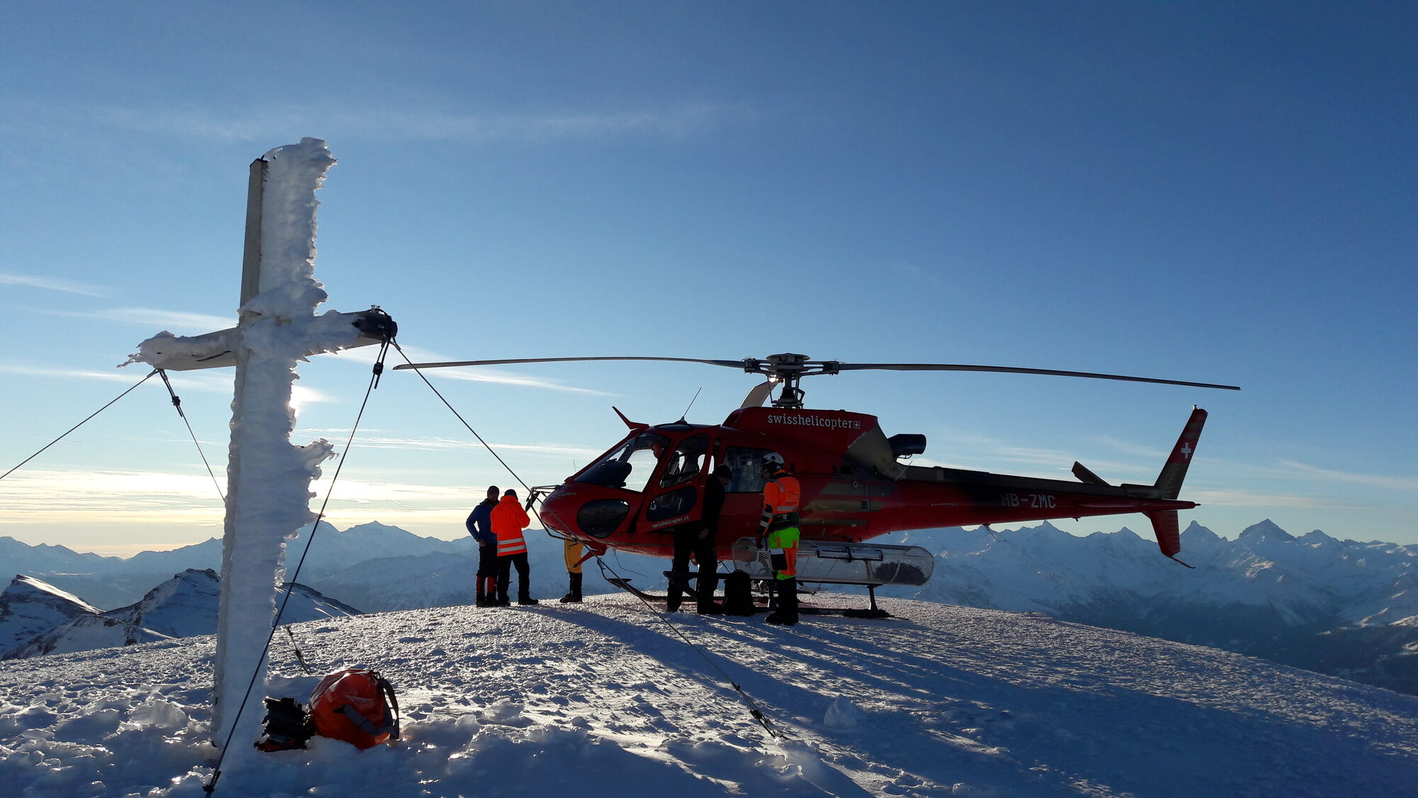 Swisshelicopter am vereisten Gipfelkreuz, Aquatos-Einbau im Hochgebirge