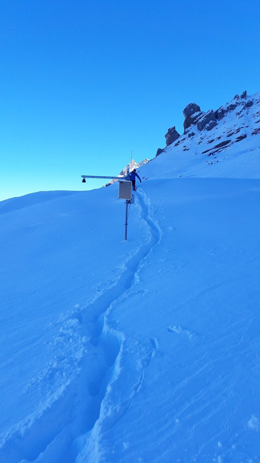 Klimastation in den Alpen: Solarmodul und Datenlogger im Schnee, Wartungs­einsatz im Spätwinter.