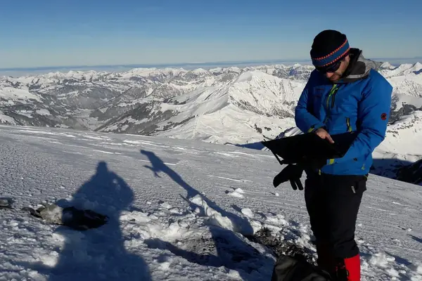 TerraTransfer-Techniker prüft mit einem Laptop die Messtechnik am Wildstrubel in den Schweizer Alpen